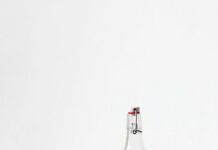 물을 충분히 마시는 방법 rocks glass beside half empty bottle on white surface