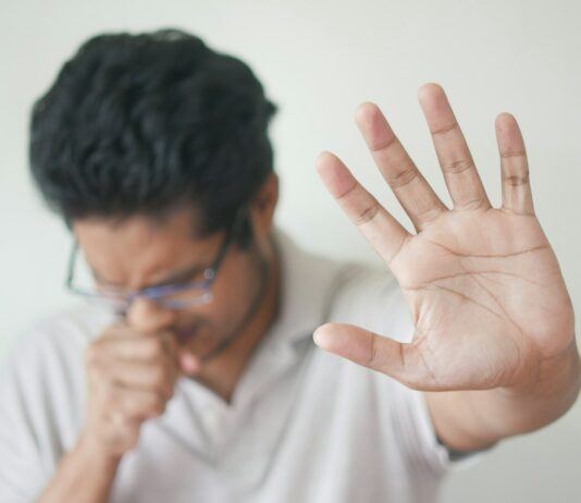 알레르기 관리: 가을 예방 전략 a man holding his hand up in front of his face