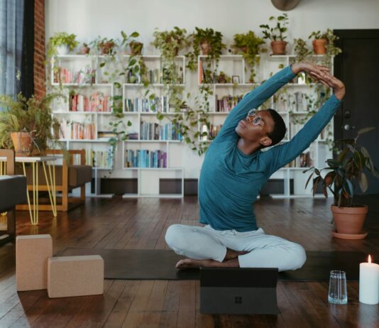 병을 예방하는 가장 쉬운 방법, 일상 속 운동 습관 들이기 a man is doing yoga in a living room