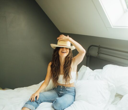 새해 맞이, 더 나은 자기 관리 비법 woman sitting on bed holding her hat