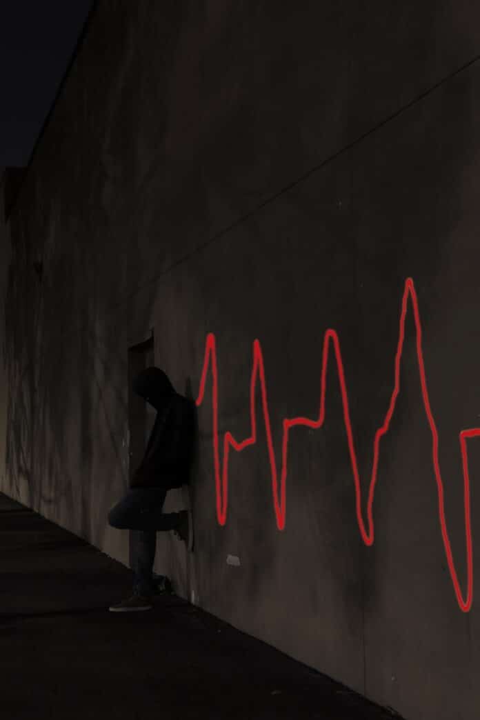 a man sitting on a skateboard in front of a wall