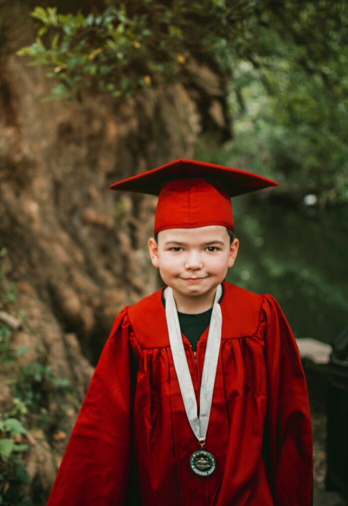 Photo by Gabriel Tovar boy in red academic robe