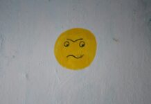감정 에너지 관리법: ‘정서 배터리’ 회복 루틴 a yellow smiley face painted on a white wall