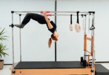 30~40대를 위한 필라테스, 건강을 챙기는 미래 트렌드 a woman doing a handstand on a pivot machine