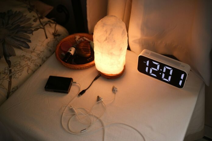Photo by Allen Y Nightstand with a lamp, clock, and chargers.