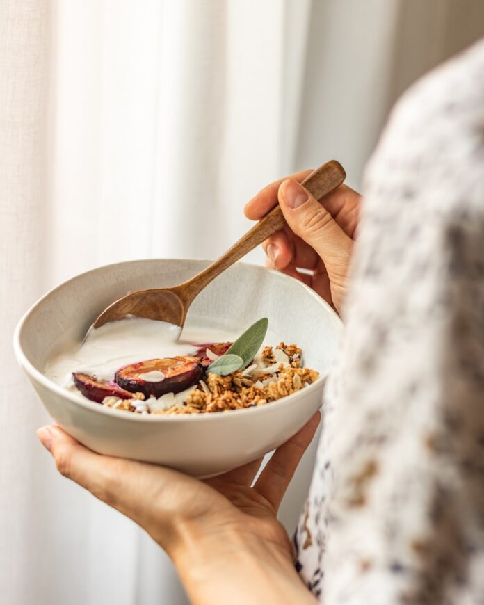 Photo by Svitlana person holding white ceramic bowl with food